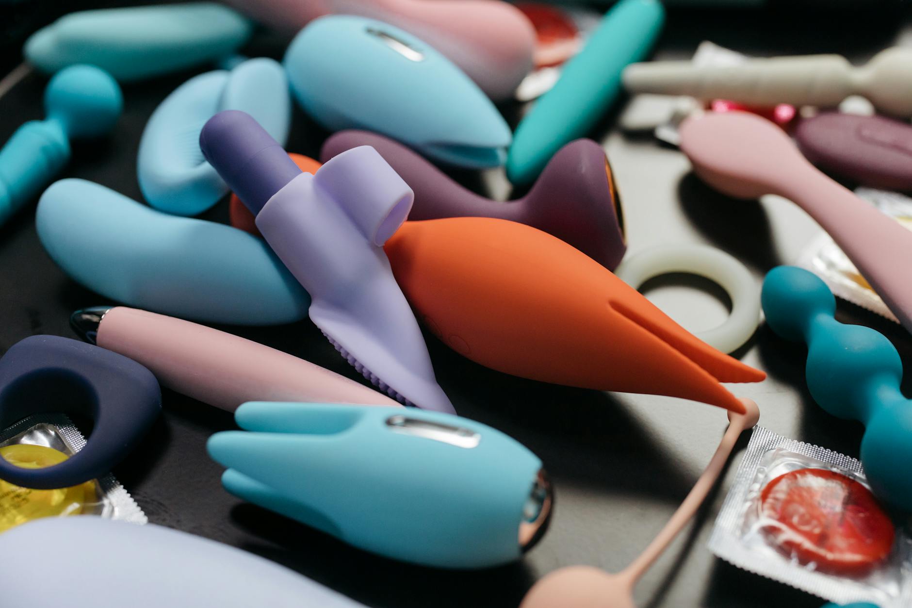 Casal jovem em pé junto, segurando um vibrador azul, simbolizando intimidade moderna e cumplicidade.