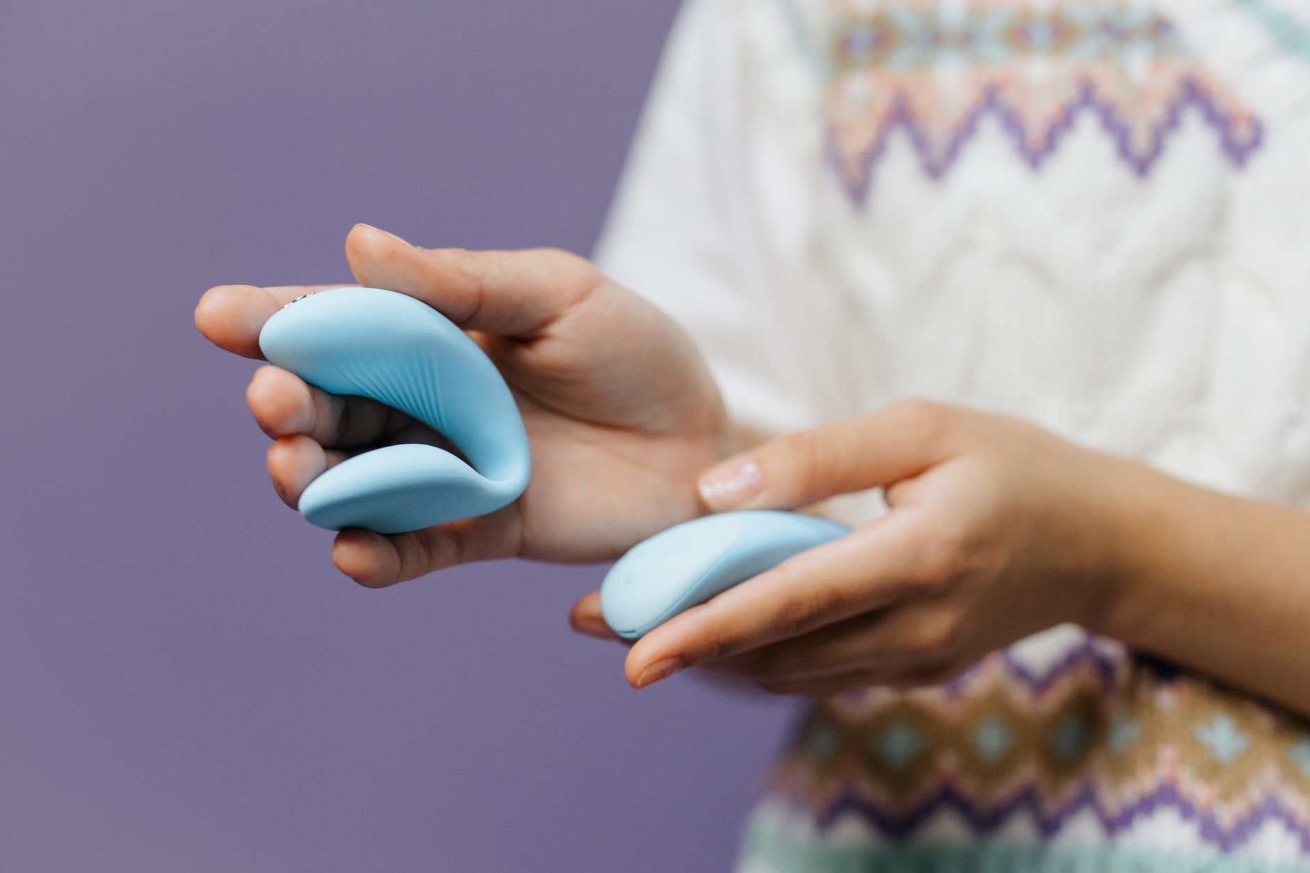 Hands holding a sleek lemon vibrator against a soft background, representing intimate self-connection after birth.