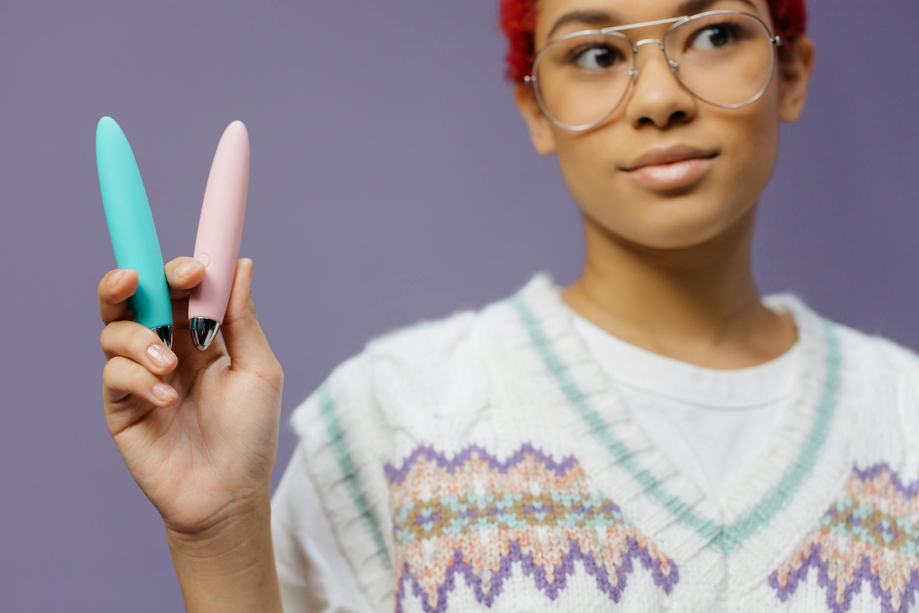 Casal jovem abraçado segurando um vibrador azul, representando intimidade moderna e comunicação aberta.