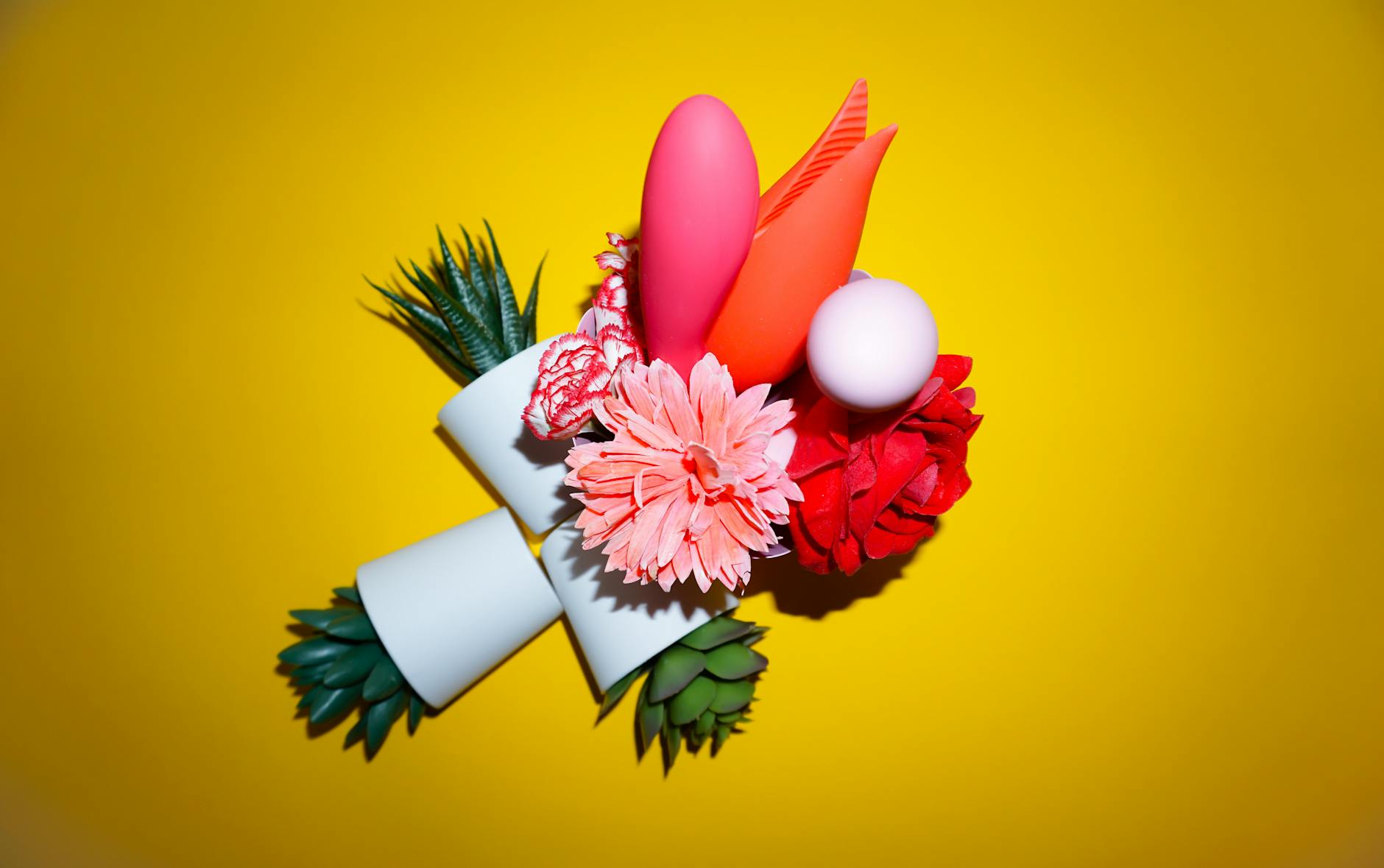 Arranjo colorido de flores e objetos abstratos em fundo amarelo brilhante